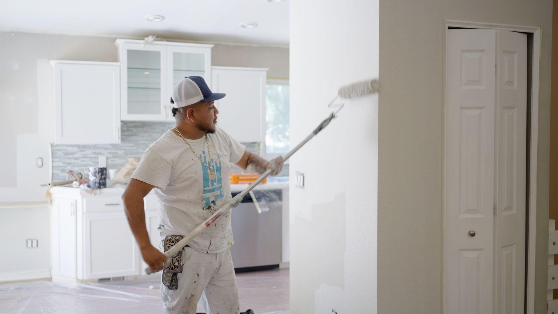 Professional painter painting trendy color on interior wall of a house