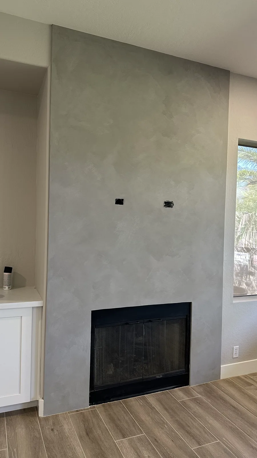 Floor-to-ceiling fireplace surround in soft grey-green limewash beside a desert-facing window applied by That 1 Painter Chandler-Gilbert