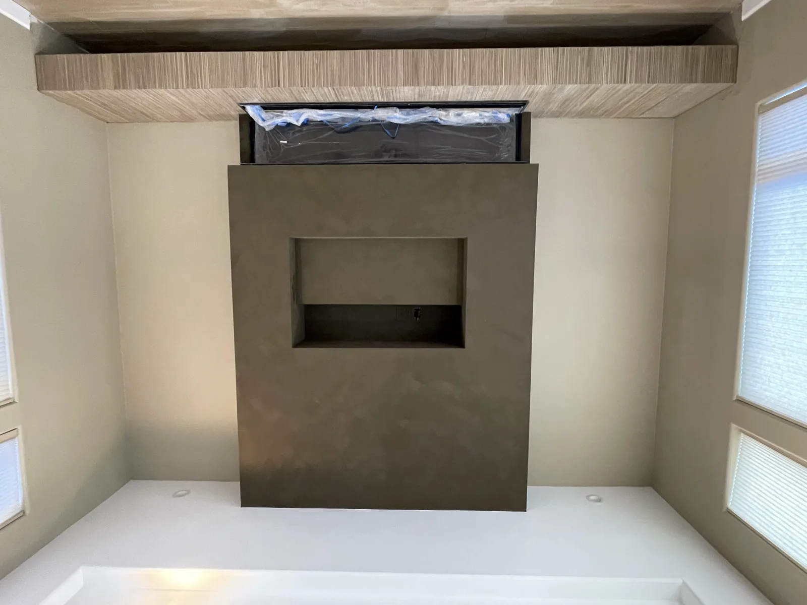 Taupe limewash fireplace surround with an inset display niche and floating wood hearth bench applied by That 1 Painter Chandler-Gilbert