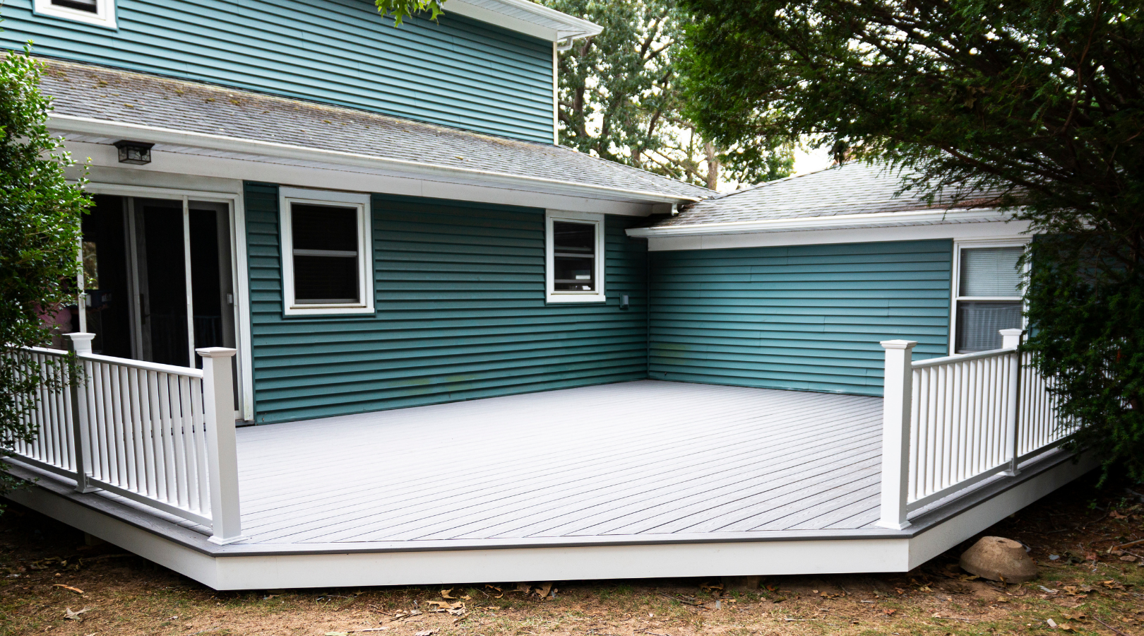 Teal-sided home with a new gray deck and white railings in Minnetonka, MN