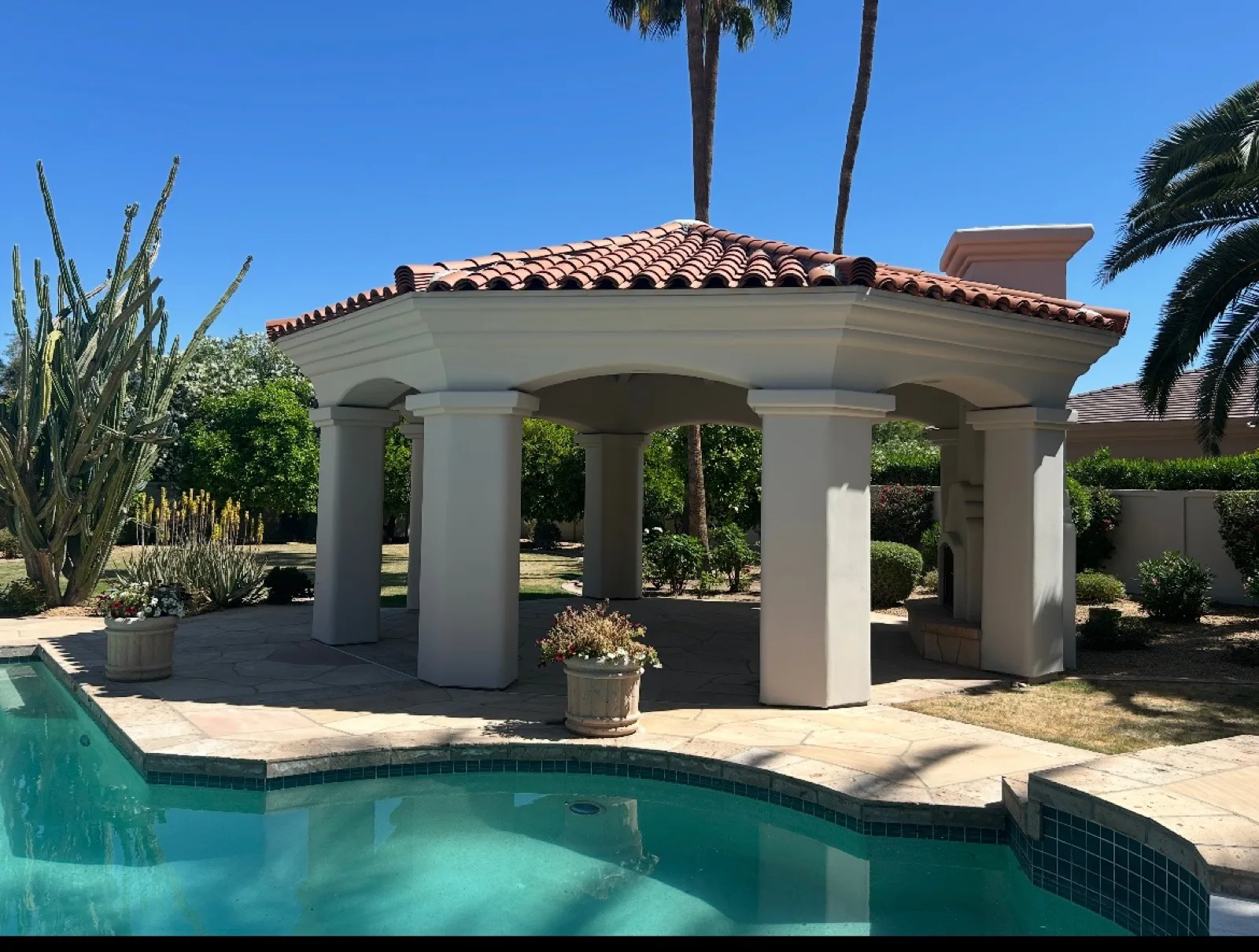 Limewashed poolside ramada with terracotta tile roof, stucco columns and saguaro cactus under desert sky applied by That 1 Painter Chandler-Gilbert