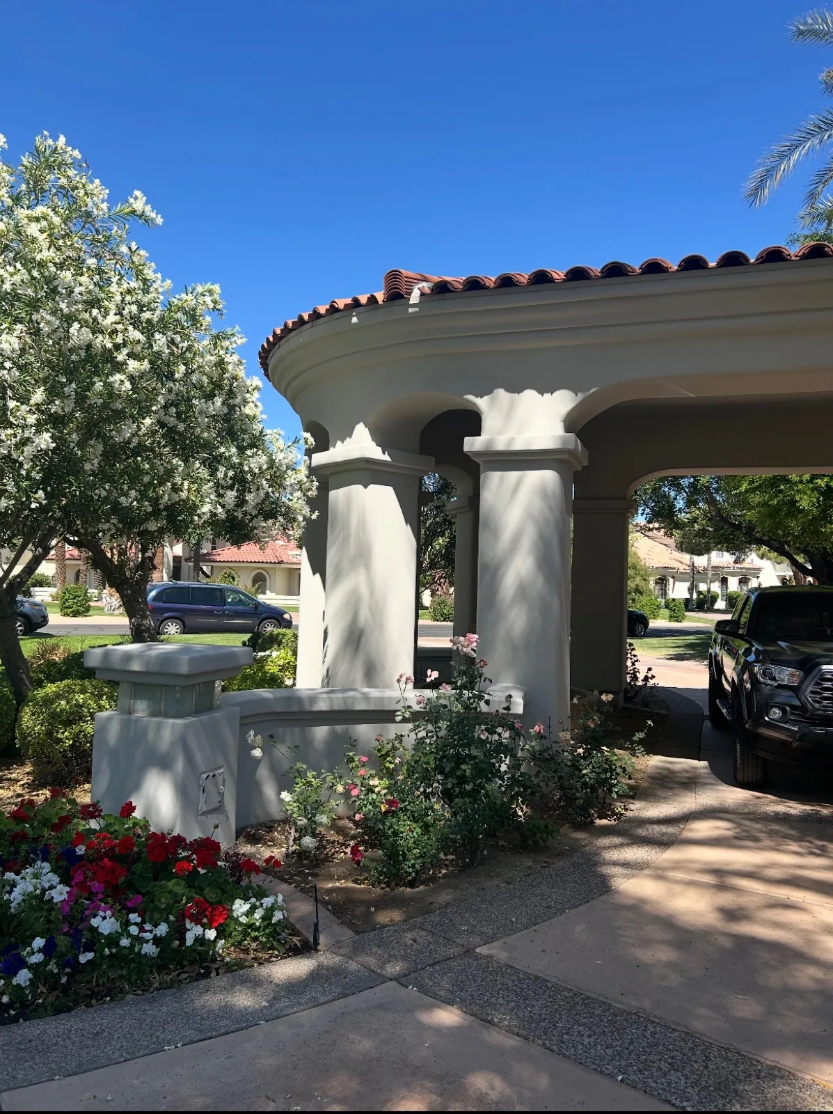 Limewashed porte-cochere columns and capitals with terracotta tile roof and rose beds applied by That 1 Painter Chandler-Gilbert