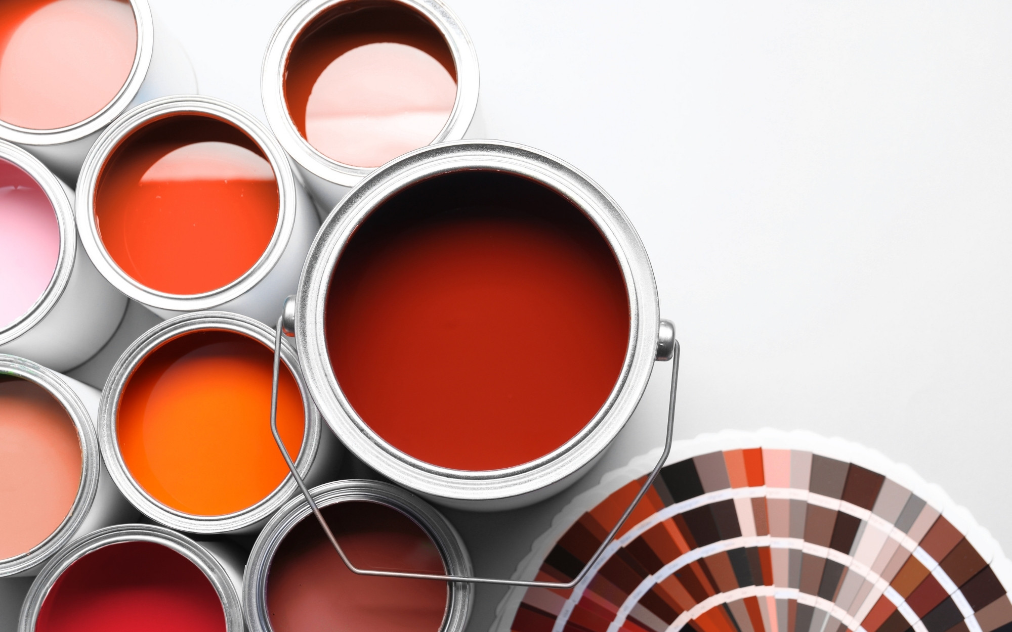 Open cans of red and orange paint with a color fan deck in Stillwater, MN