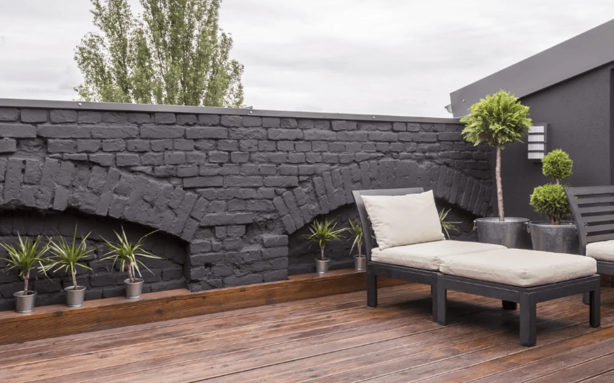 Dark painted brick patio wall with modern outdoor living space