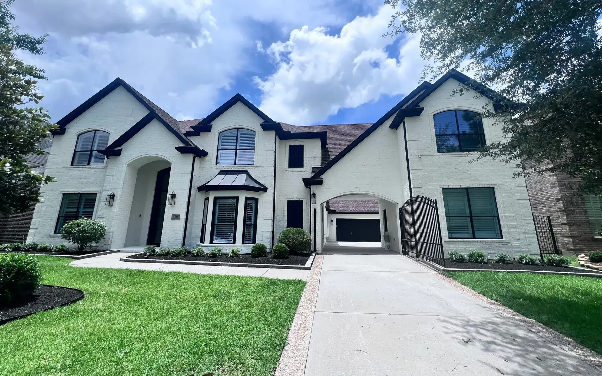 Large two-story painted brick home with dark trim in North Detriot
