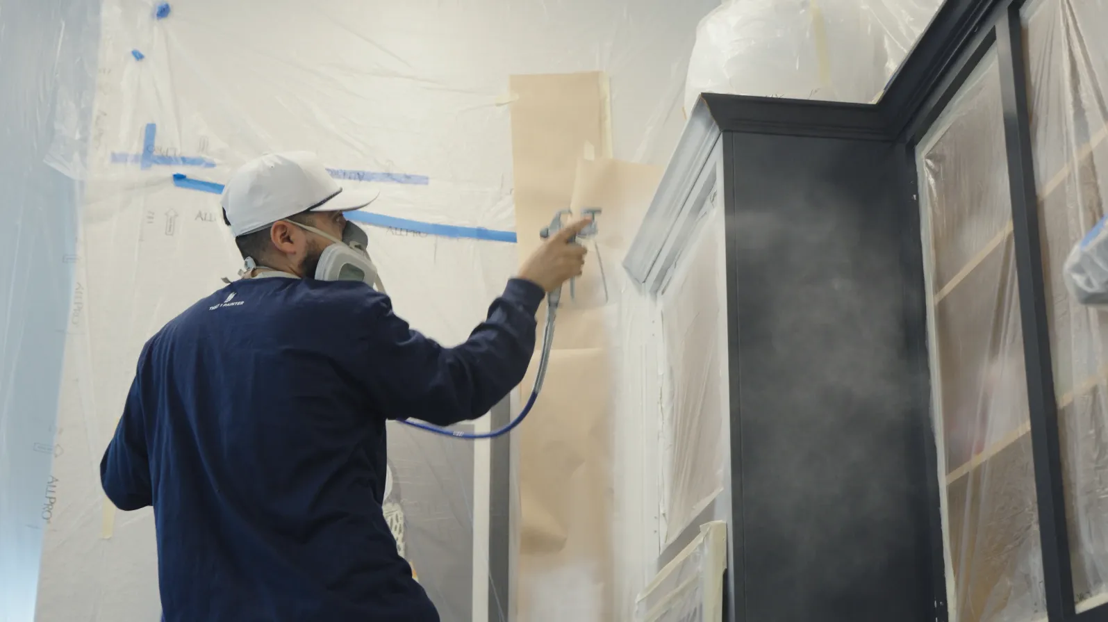 Cabinet doors being sprayed in a controlled containment area