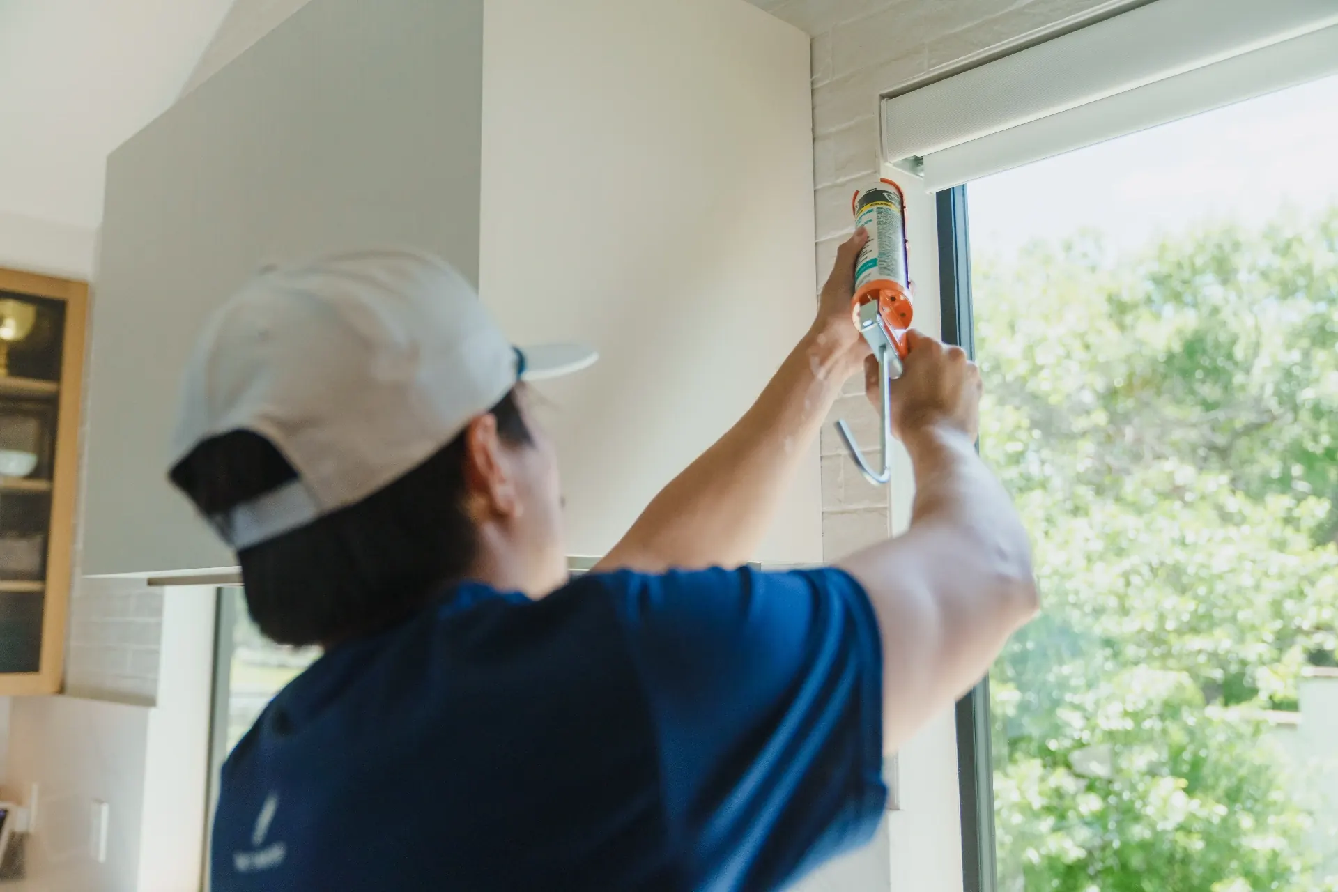 Interior caulking pass along a window frame above the kitchen counter