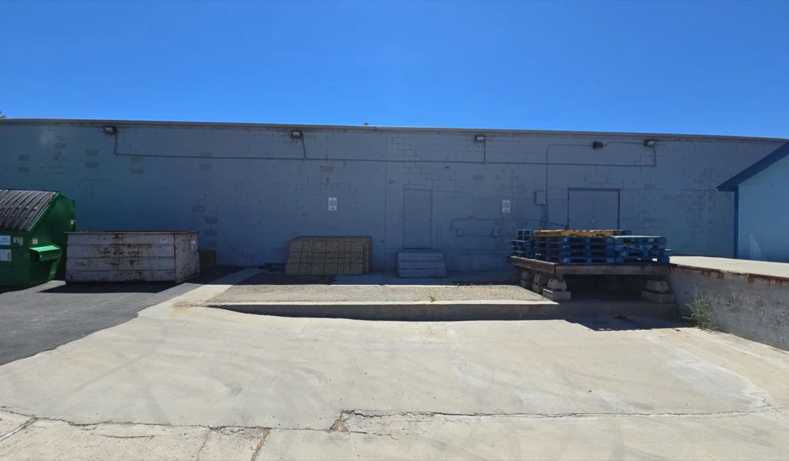 Warehouse loading elevation in dated blue-grey block before repainting by That 1 Painter Treasure Valley