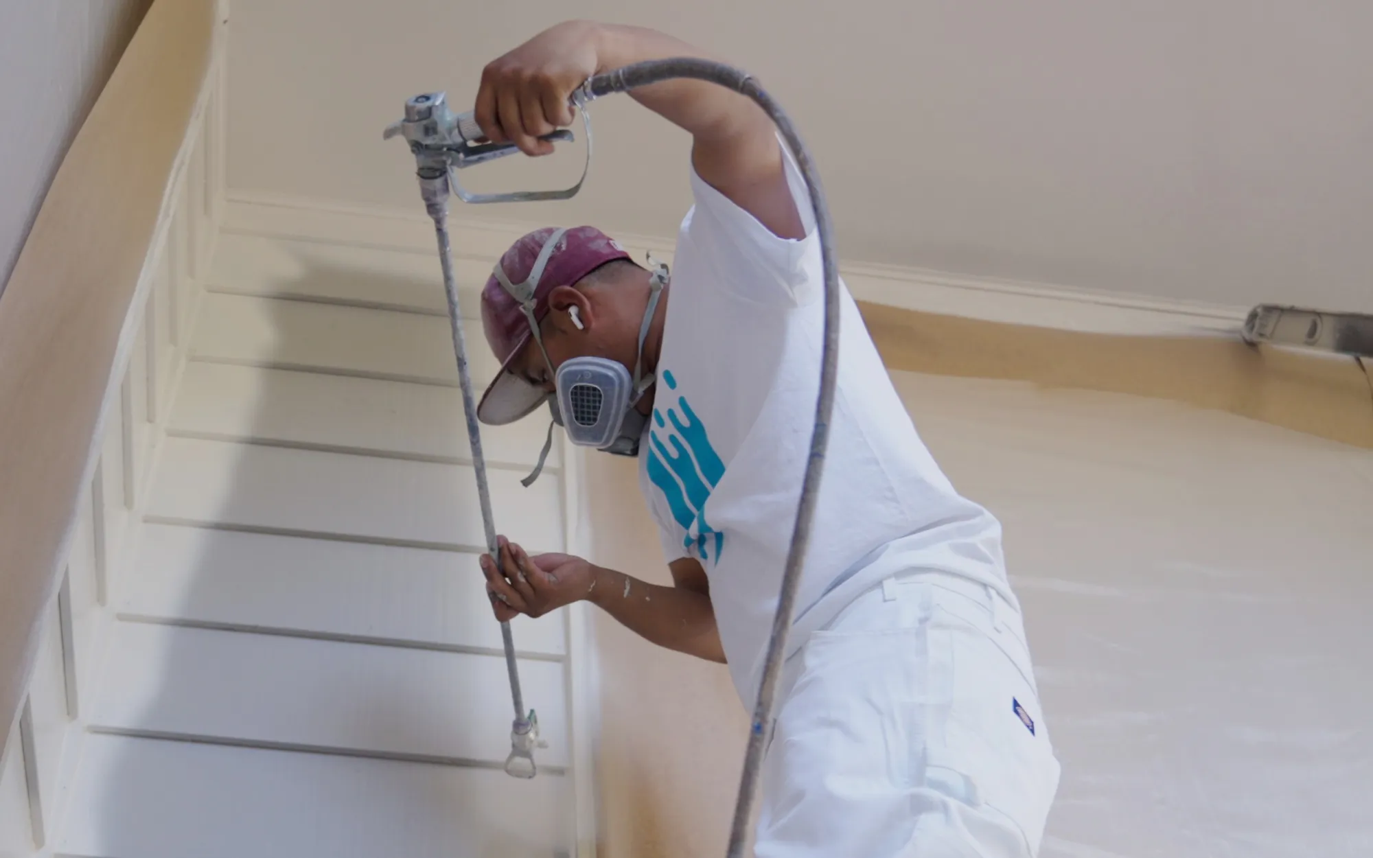 Professional painter spraying exterior soffits and trim