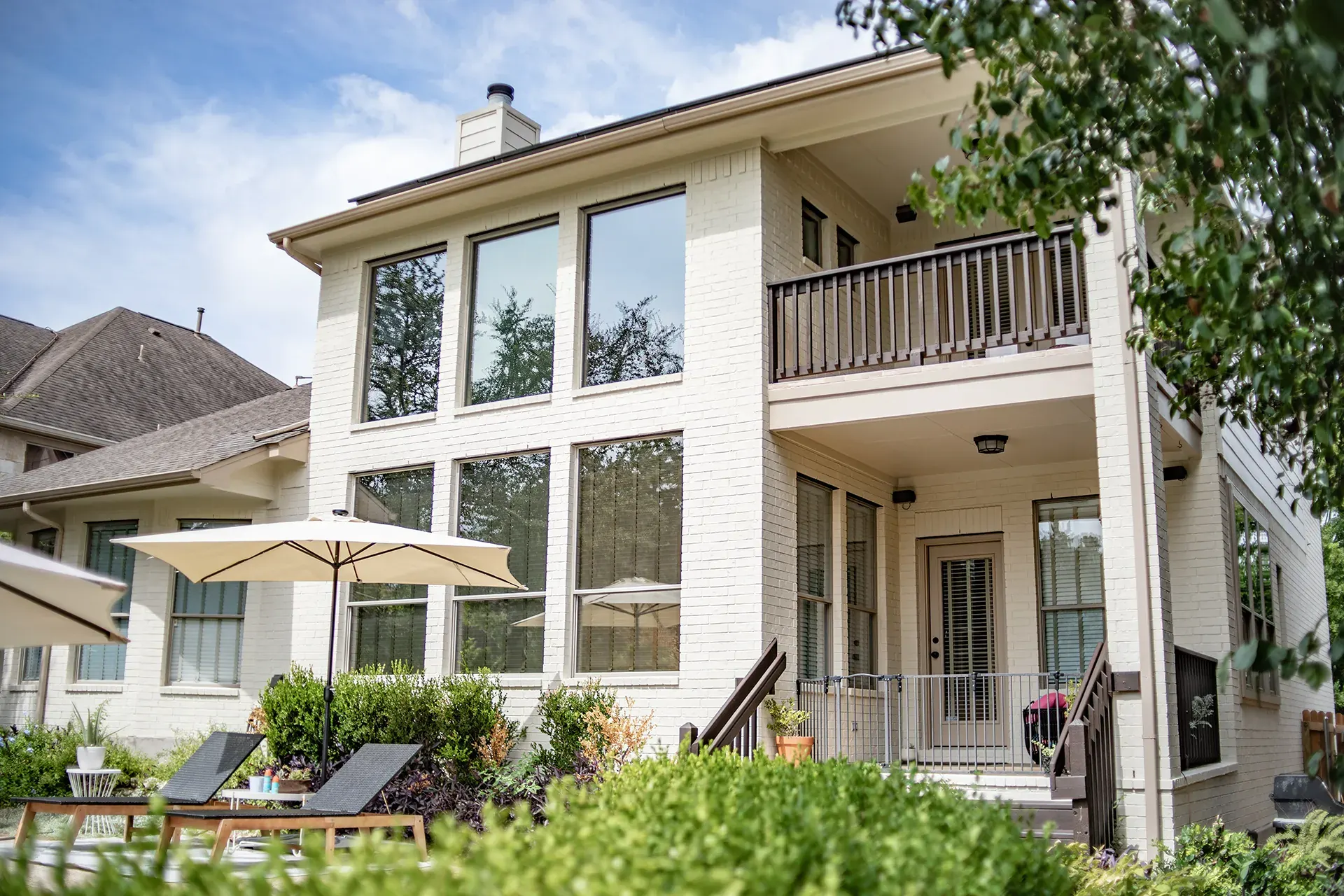 Painted brick backyard exterior with balcony and patio