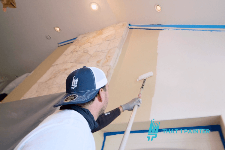 Painter rolling primer on a tall interior wall in Maple Grove, MN
