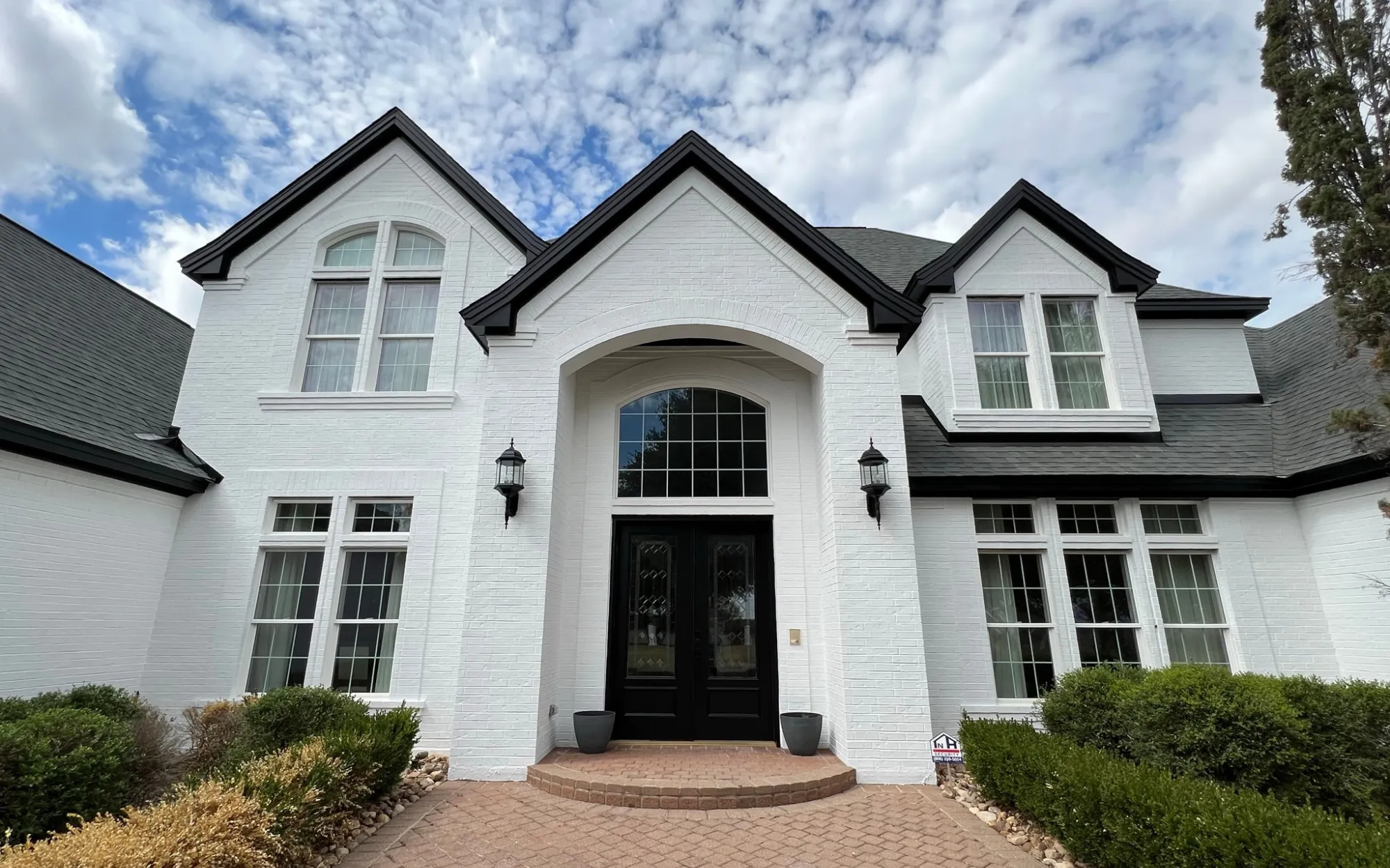 Homeowner reviewing fully cured limewash finish on brick home during final walkthrough