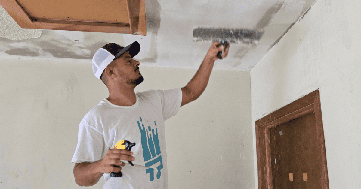 Crew member finishing ceiling after popcorn removal in Bellaire