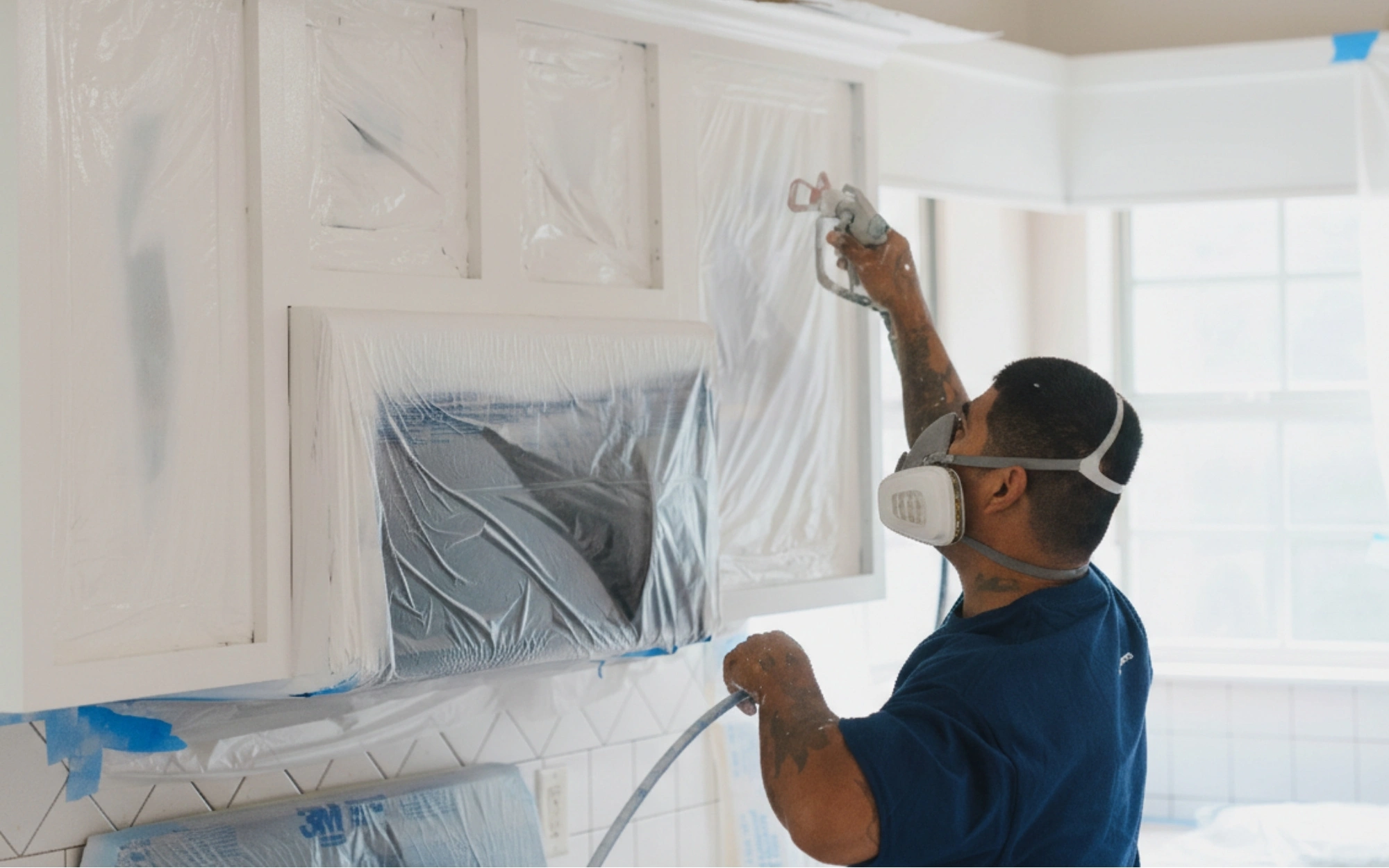 Professional painter applying a precision coat with clean tape lines and protected interior surfaces