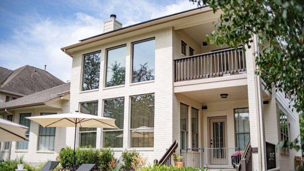 Brick Exterior Backyard_That 1 Painter Austin_ White Brick house with railing.