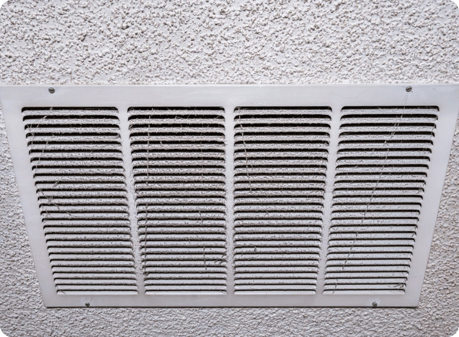Close-up of a dirty air vent on a popcorn ceiling with dust and cobwebs accumulated between the vent slats with that 1 painter