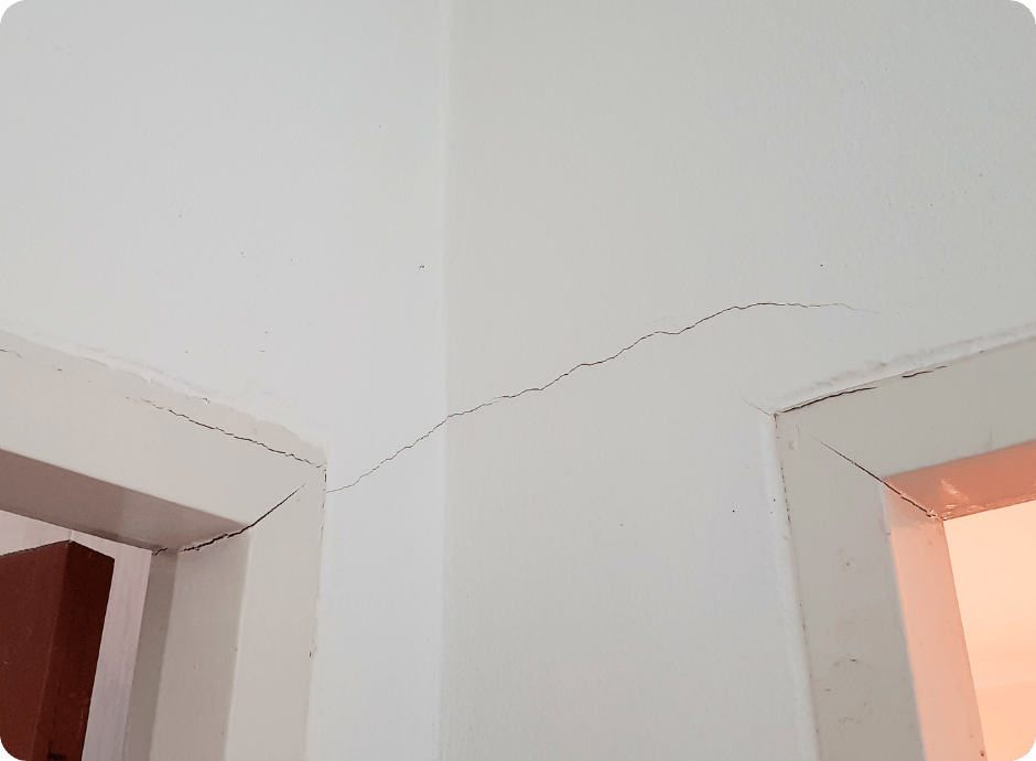 Cracks running across the corner of two walls above door frames in need of repair services with that 1 painter