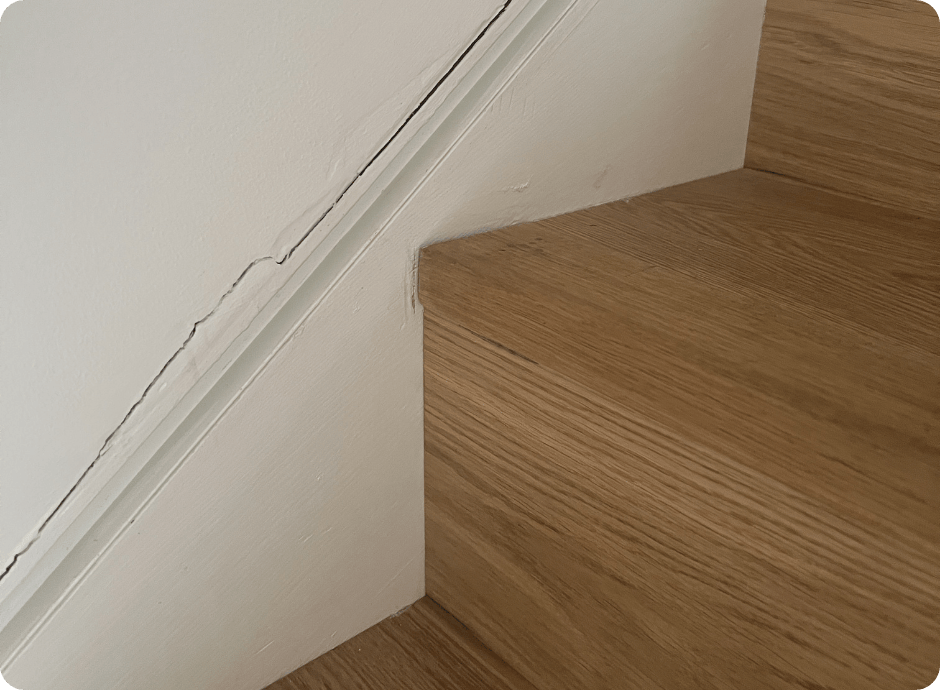 Wall and trim separation above a wooden staircase needing repair services with that 1 painter