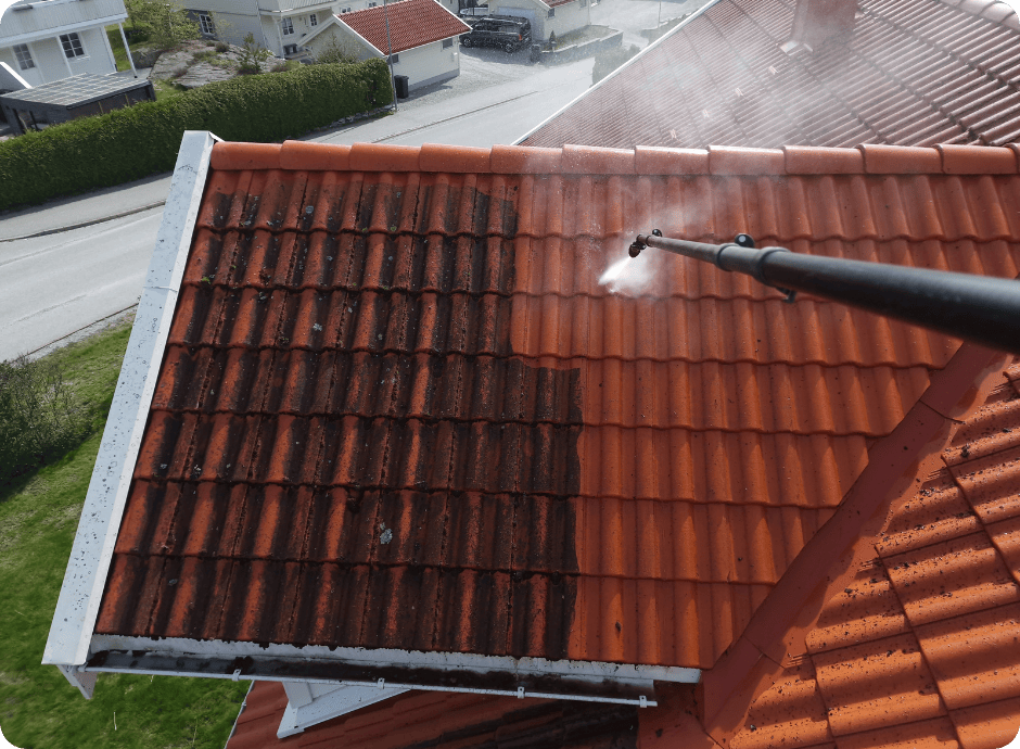 High-pressure washing removing moss and dirt from red roof tiles for that 1 painter