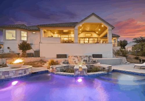 Exterior of a large house in Westlake with a lit pool and large patio painted by professional painters