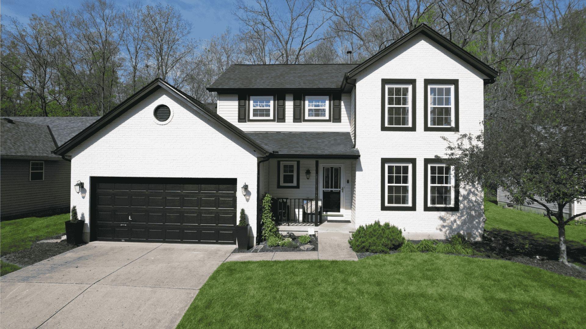 a freshly painted two story brick home with white paint and black trim_by expert exterior painters from that 1 painter bell county