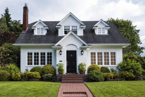 White house with white trim, professionally painted in Jefferson, Oregon, featuring a landscaped front yard.