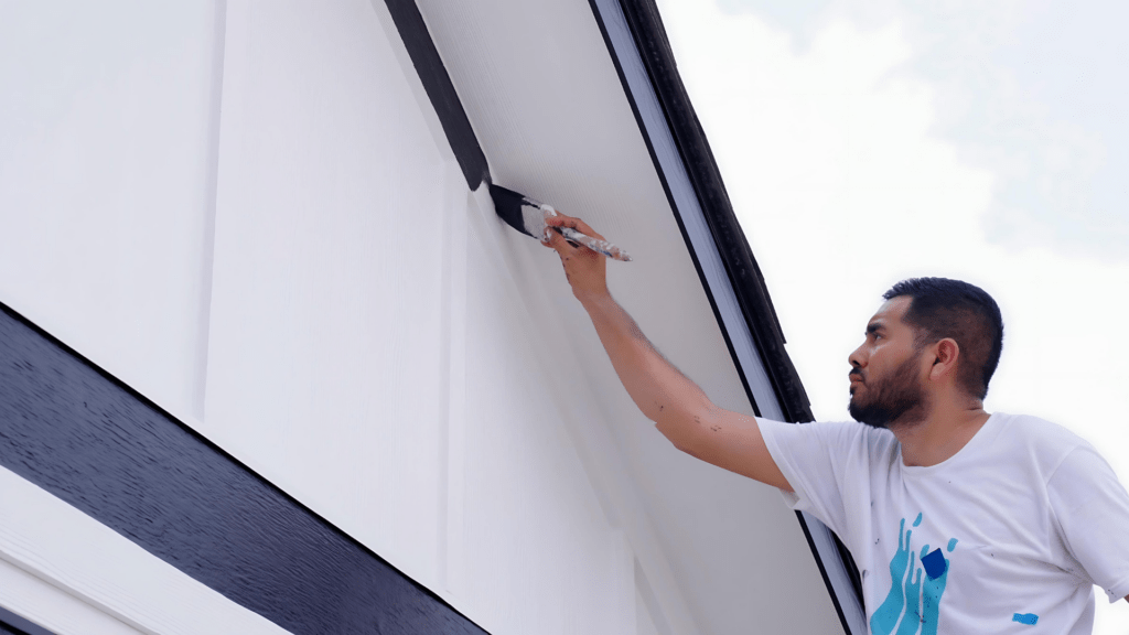 Expert painting services taking place on the outside of a white home with black trim - That 1 Painter East Austin Bastrop