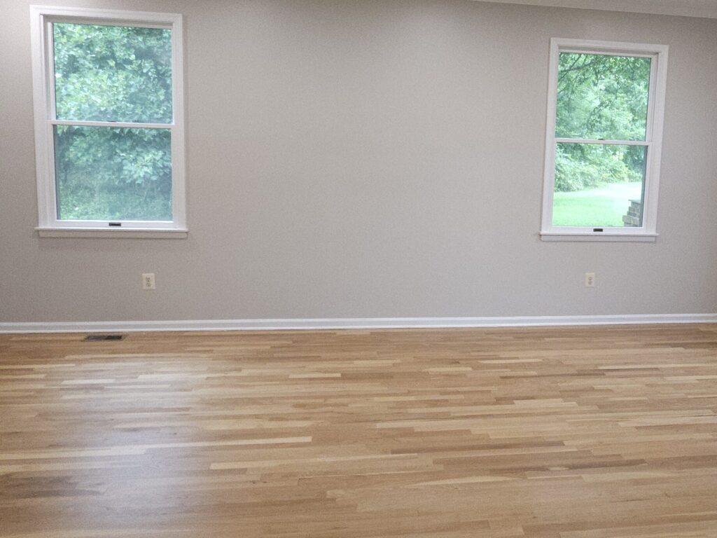 white wall with brown wood floors and two windows for home renovation for that 1 painter essex