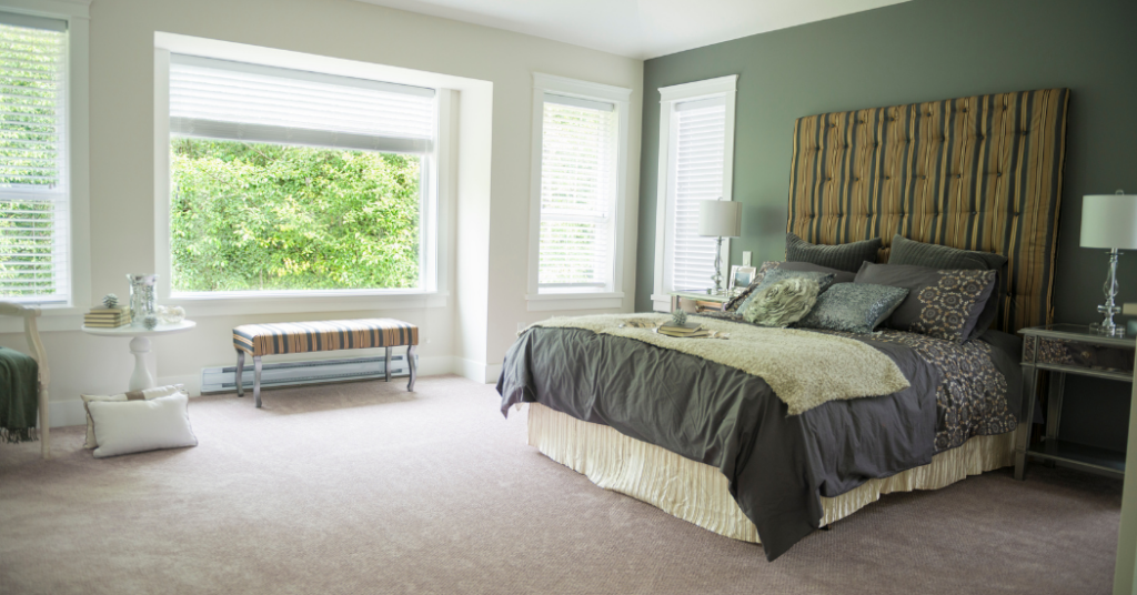 The accent wall of a bedroom is painted green by That 1 Painter Houston