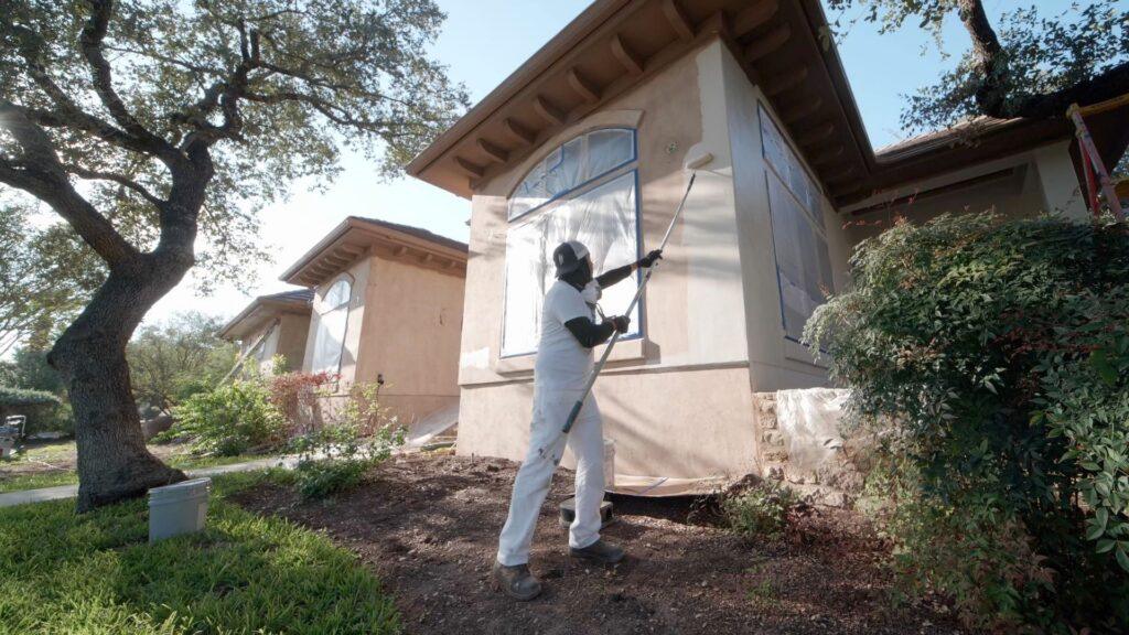 Painters in Houston doing stucco repairs on the exterior of a home - That 1 Painter Houston