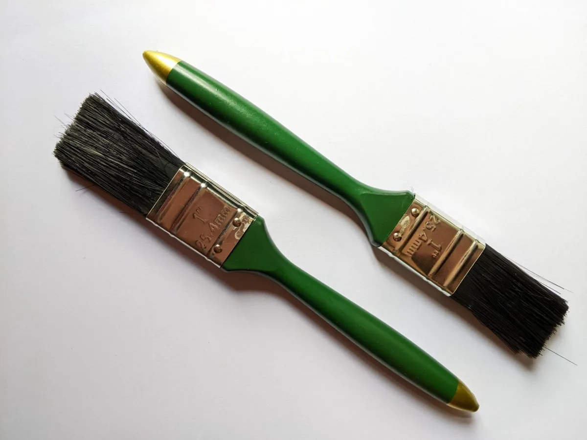 Two one-inch natural bristle paint brushes with green handles
