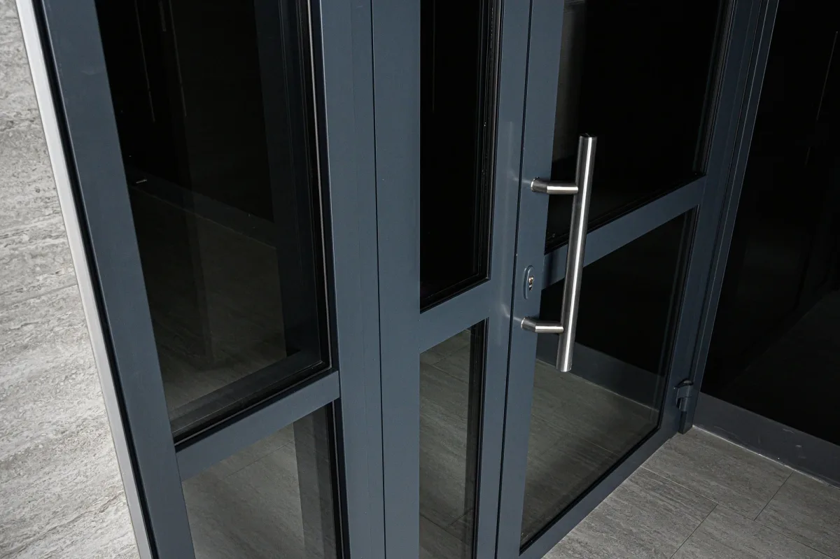 Close-up of charcoal gray framed glass double doors with stainless steel pull handles
