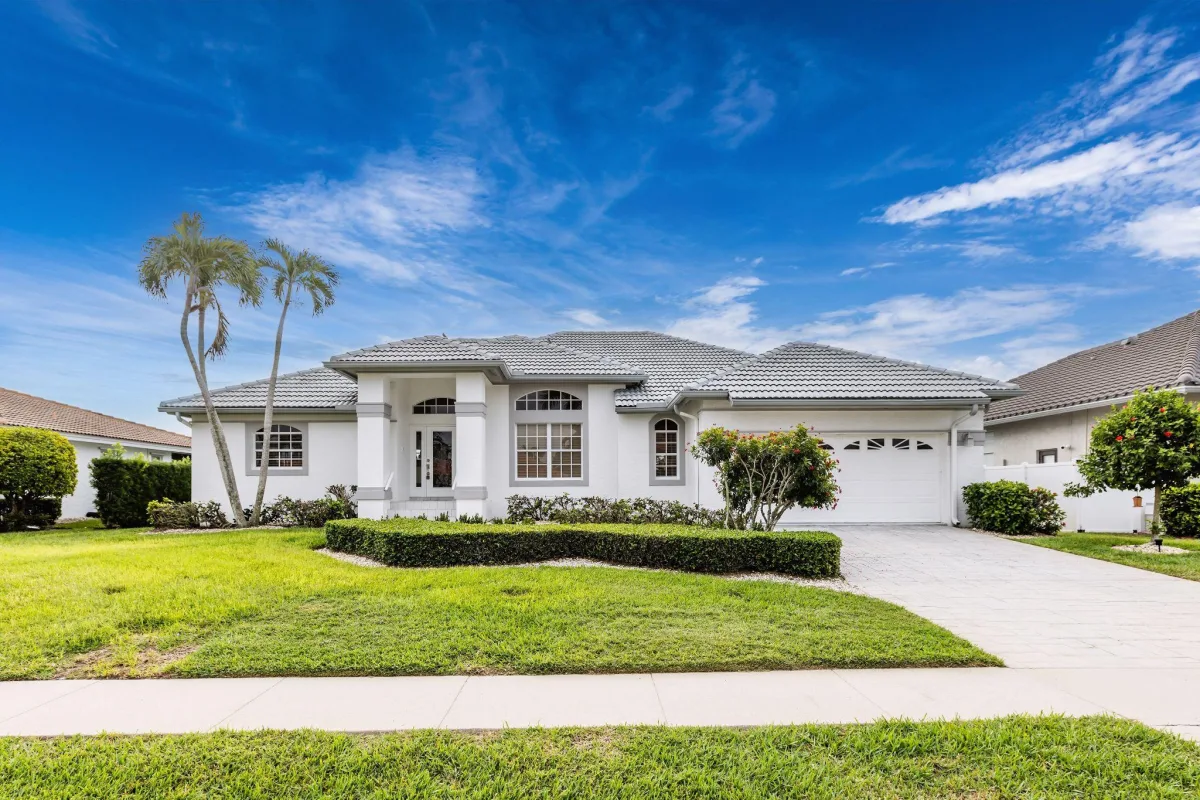 Stucco home with tile roof under a bright blue sky