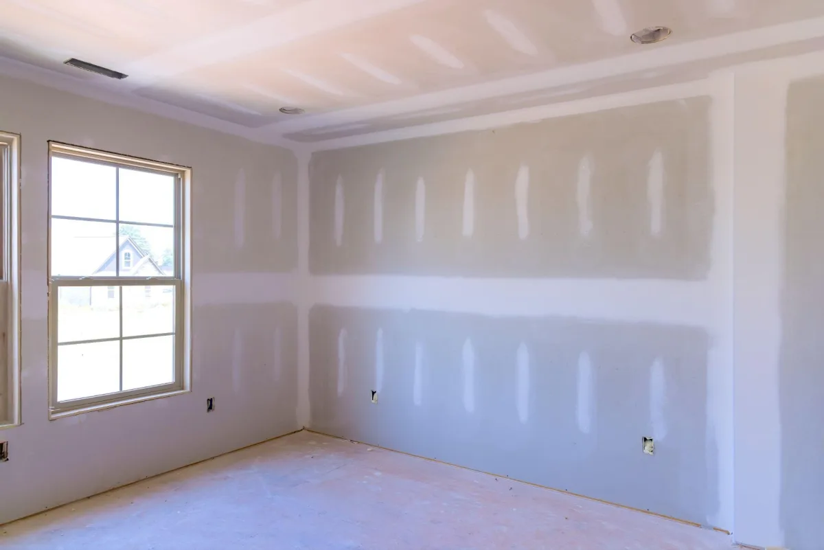 Freshly finished smooth drywall in an empty room before painting