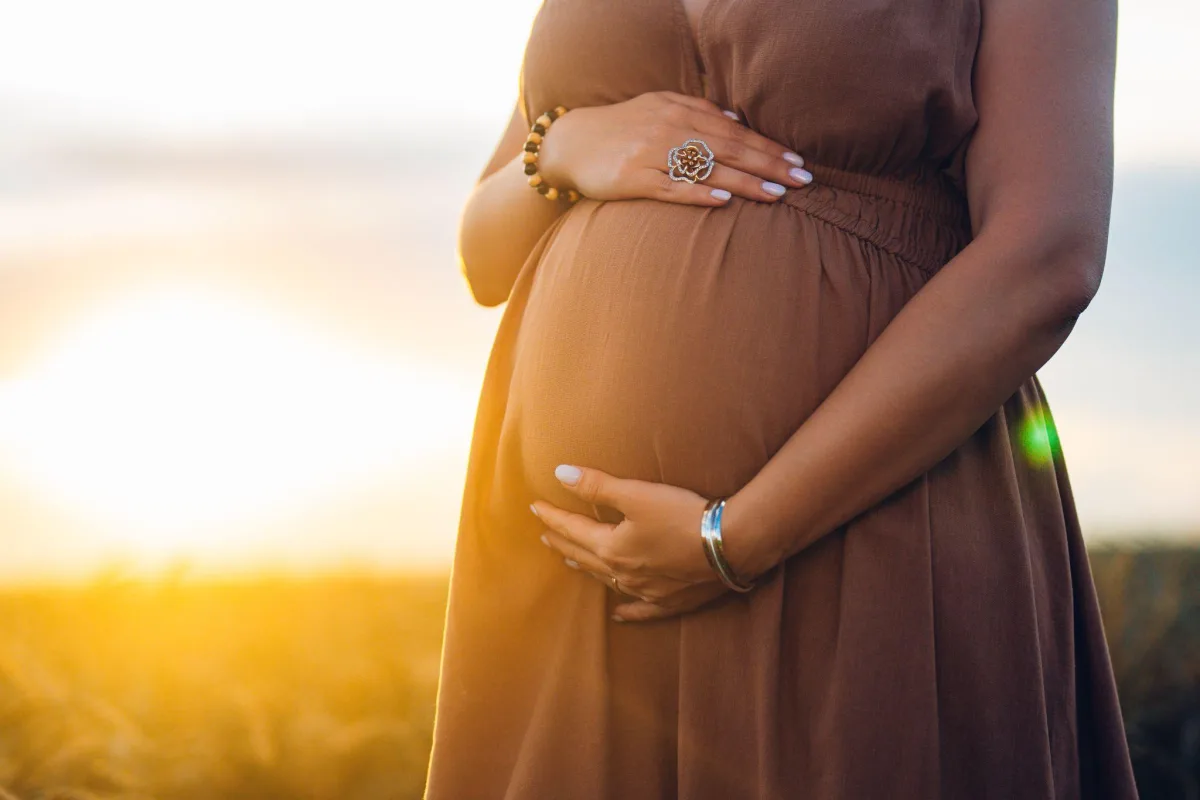 Pregnant woman standing in soft natural light