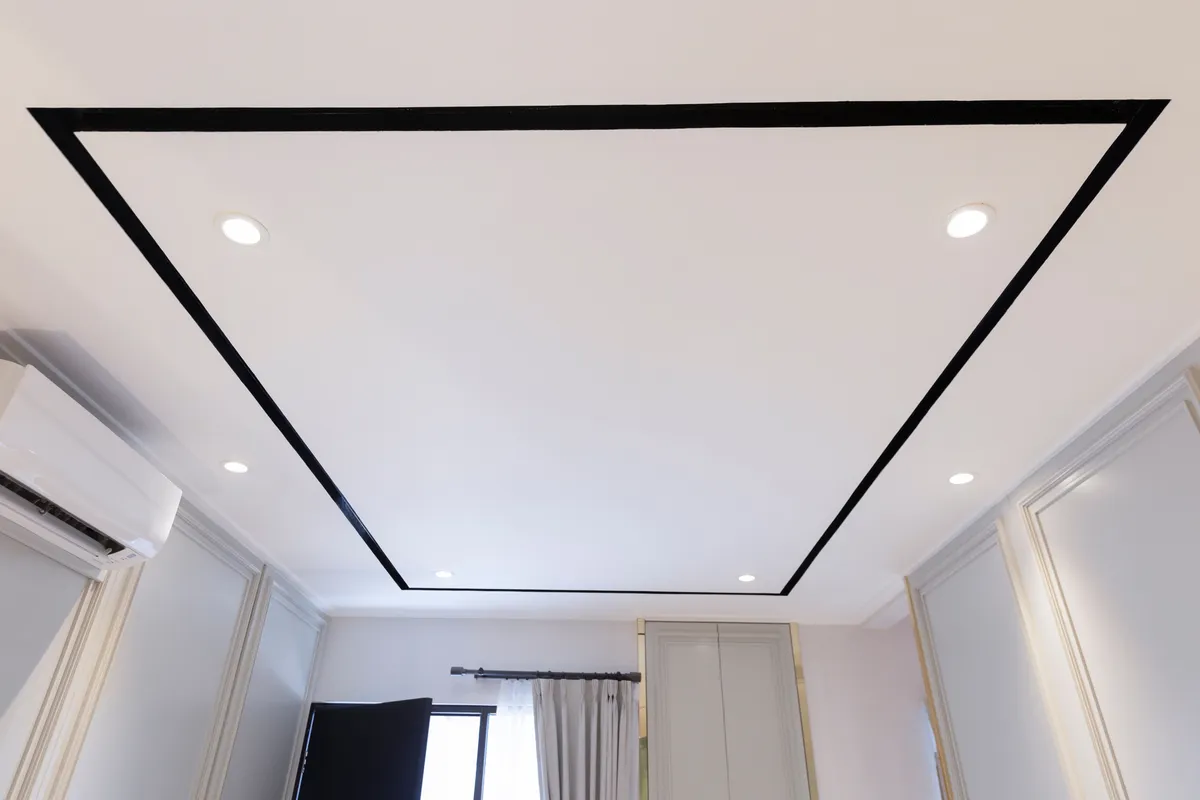 Smooth white living room ceiling with recessed lights after popcorn texture removal
