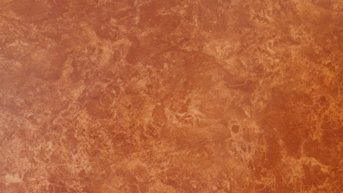 Close-up of a warm terracotta mottled plaster wall texture
