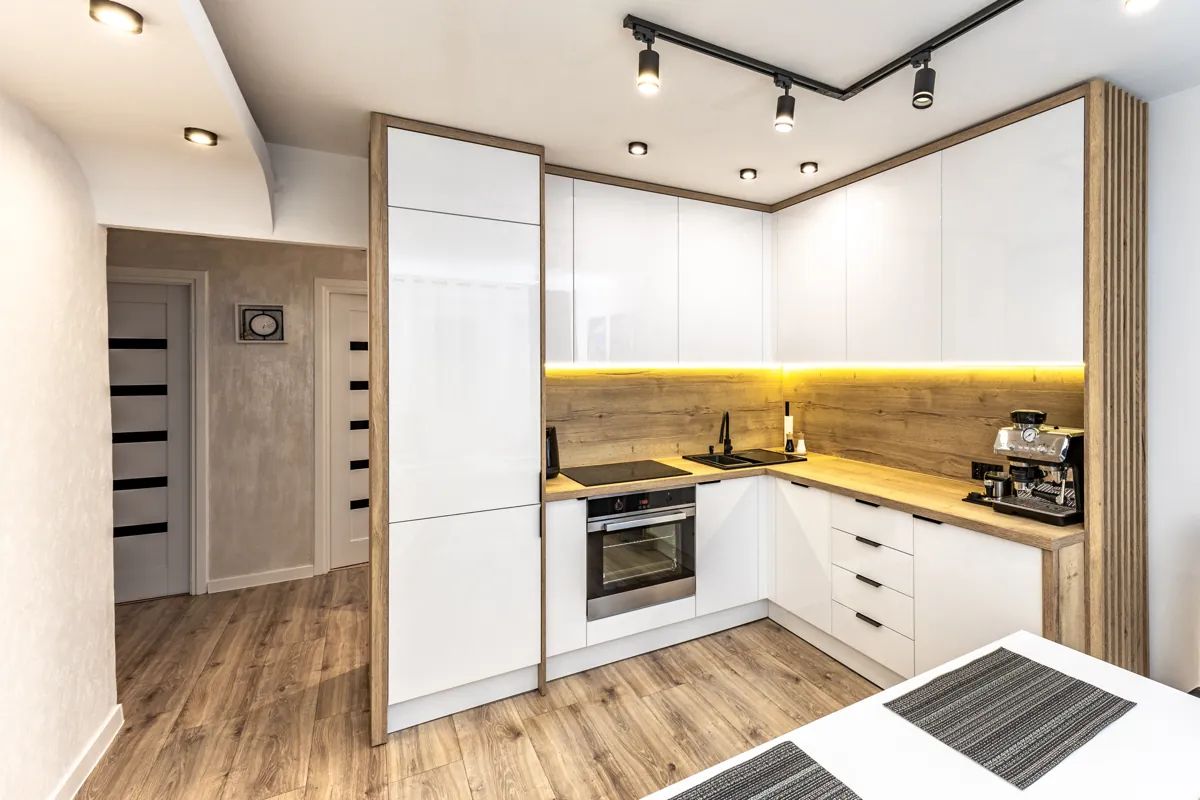 Modern kitchen with white painted cabinets, wood countertops and under-cabinet lighting