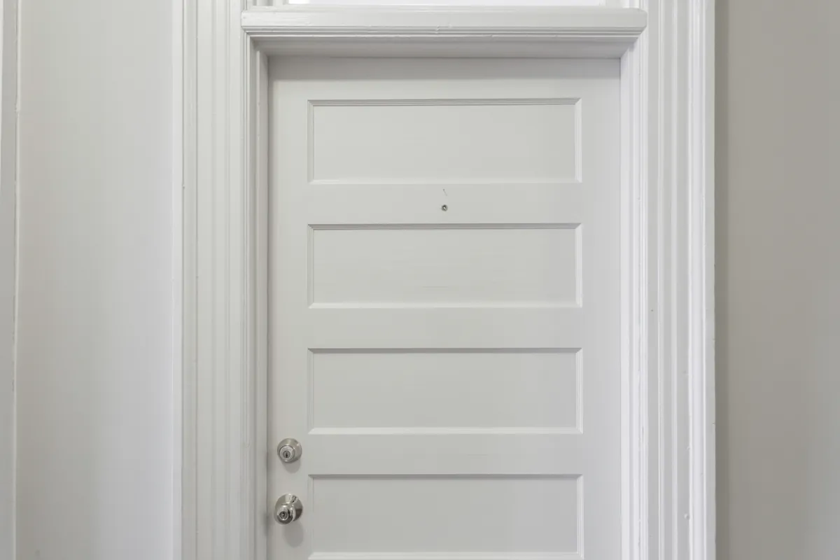 White paneled interior door with crisp painted casing and trim
