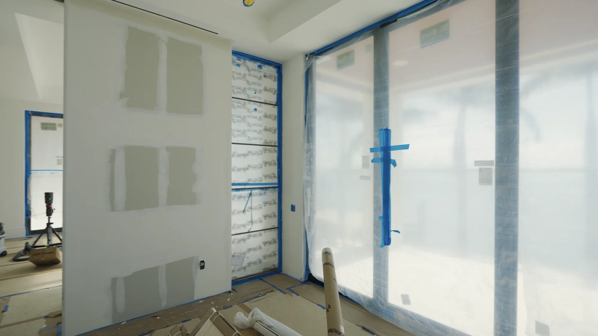 Masked windows and patched drywall prepped for interior painting in St. Petersburg, FL