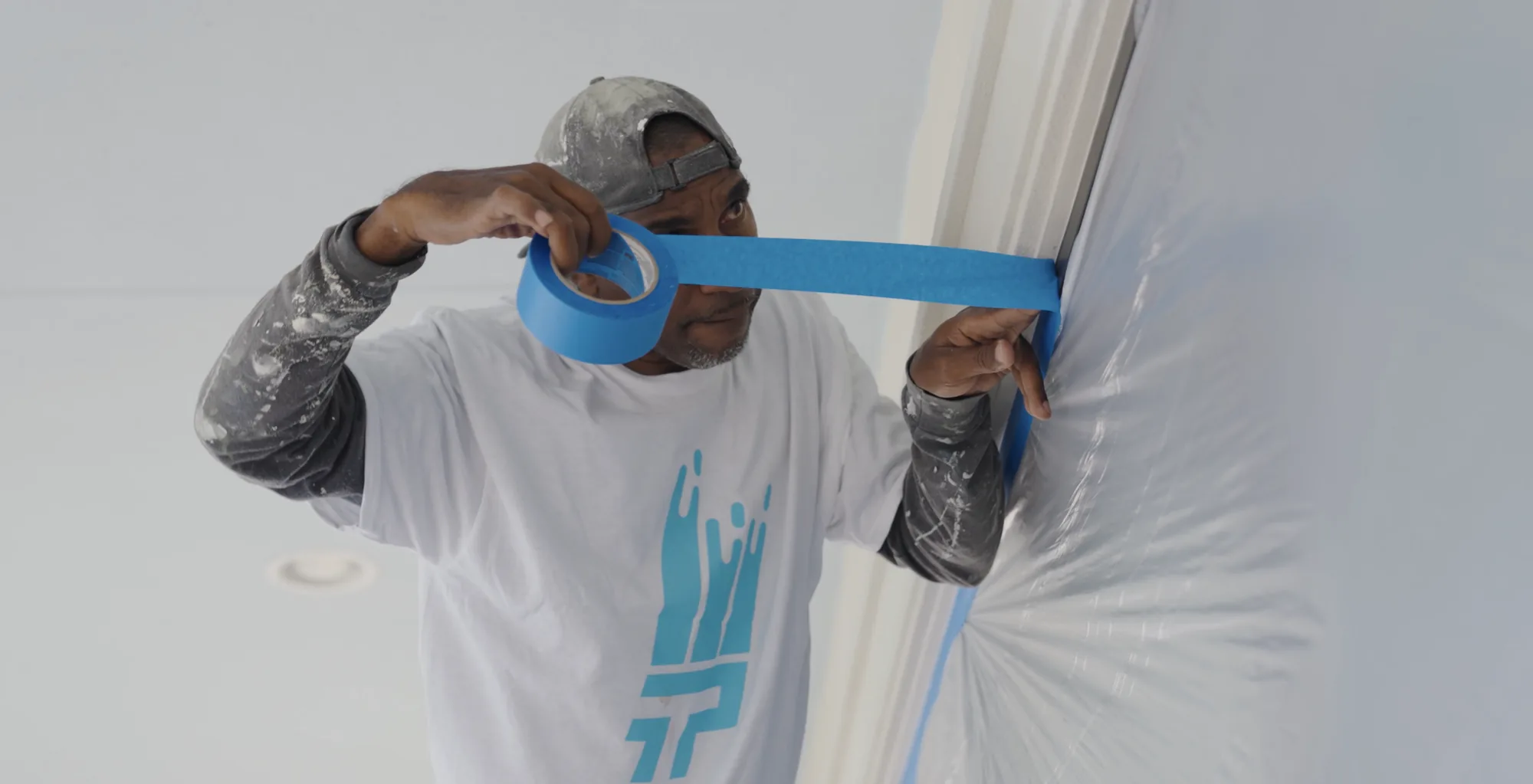 That 1 Painter St. Petersburg crew taping trim and sheeting before an interior repaint in St. Petersburg, FL