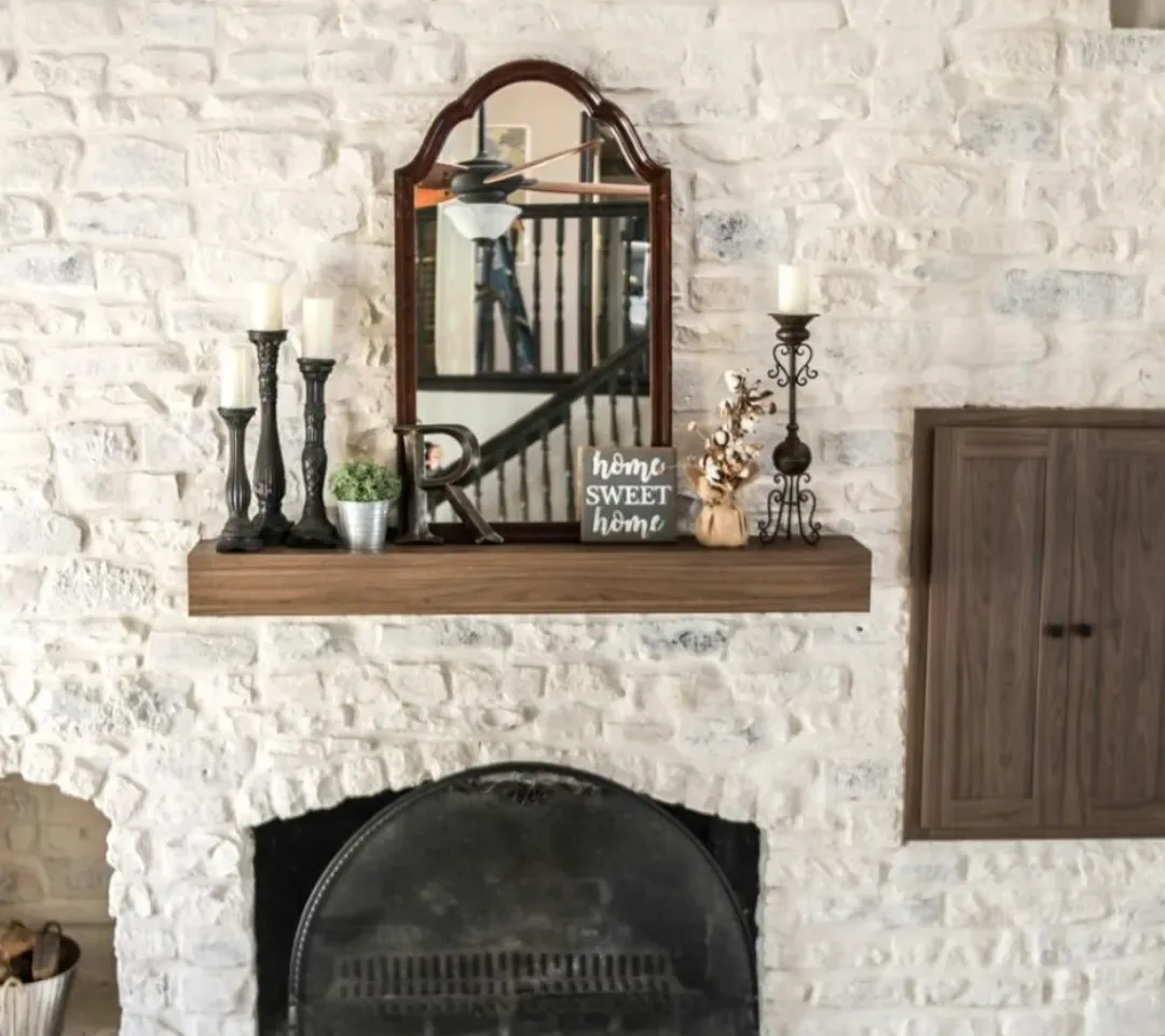 Painter brushing limewash across a brick fireplace surround inside a Mt Lebanon - PA living room