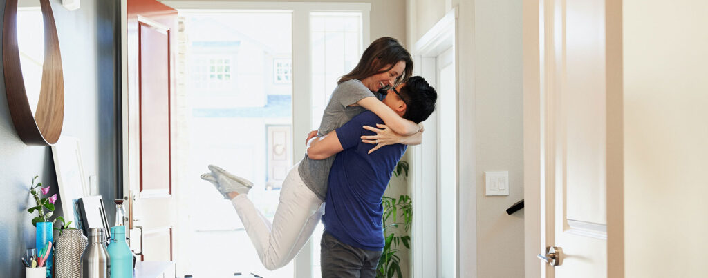 A couple embracing in their home after a fresh paint job with kid-friendly paint by That 1 Painter Louisville