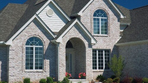 Exterior of a limewashed brick house with white accents painted by painters in Midland