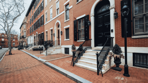 Beautiful red brick townhouse with dark door and dark window panels painted by professional painters in Spring City, PA