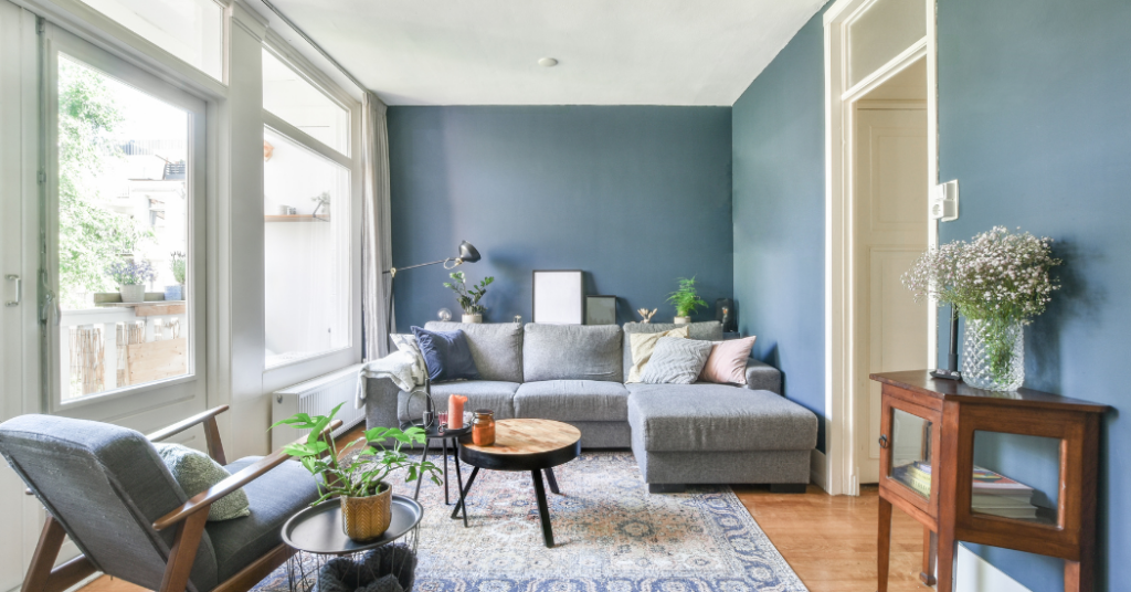 A living room painted blue with a room full of furniture - That 1 Painter Naples.