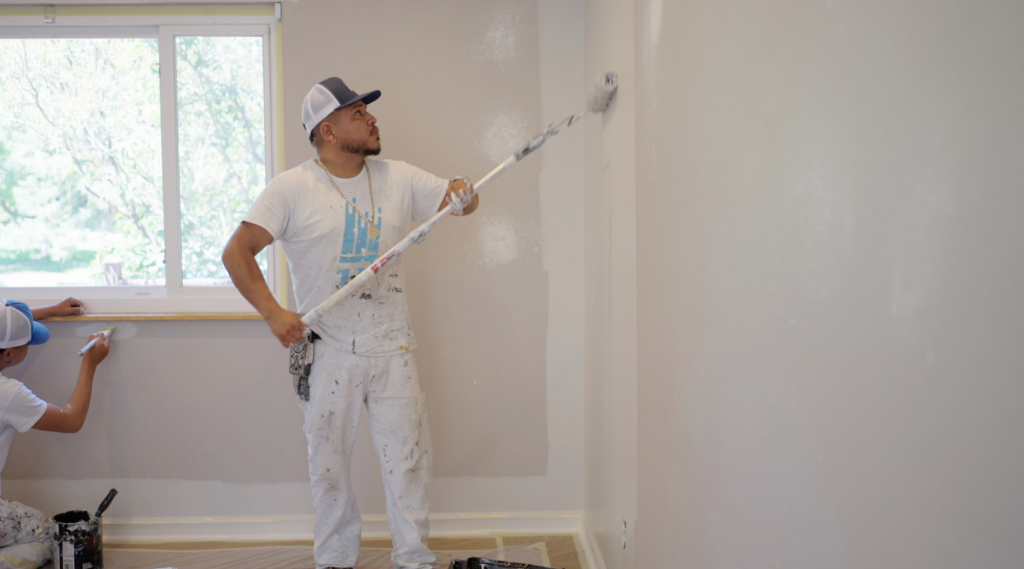 house painter painting the wall with white paint and a roller for That 1 Painter_New Braunfels