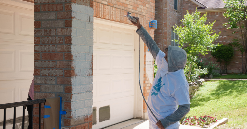 That 1 Painter New Orleans painting a brick pillar on the exterior of a historic home.