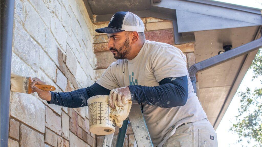 A painter using Romabio Lime Wash to paint a brick house in New Orleans - That 1 Painter New Orleans.