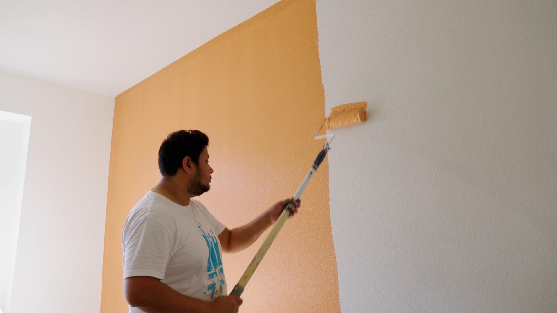 A photo of a man painting a wall orange from That 1 Painter North Jersey - accent walls
